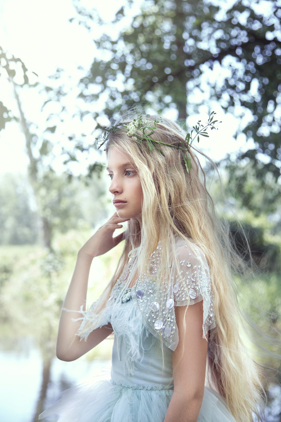 Woman in a sequined dress wearing a floral crown outdoors.
